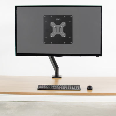 Translucent screen highlighting VESA mount adapter connected to a monitor mount.