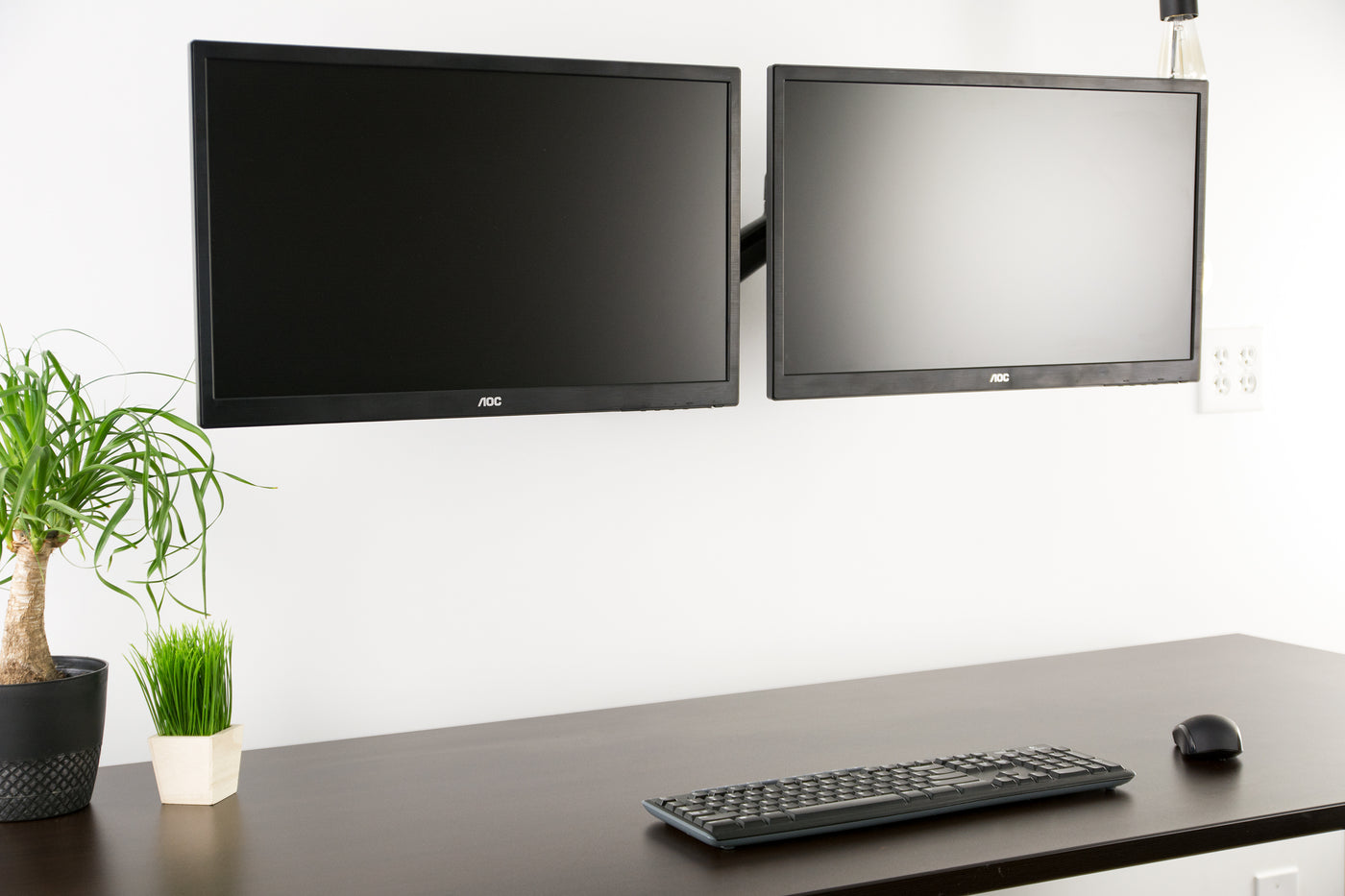 Dual pneumatic wall mount supporting two monitors.