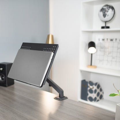 Laptop stand plate supporting a closed laptop at an ergonomic angle.