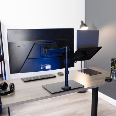 Freestanding monitor and laptop stand with elegant glass base for dual screen viewing and ergonomic placement.